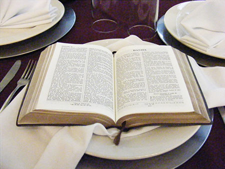Esta Biblia abierta sobre un plato ilustra el tema Nutrido con las palabras de la fe y de la buena doctrina, sermón de texto completo en editoriallapaz.