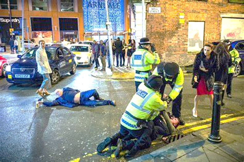 Una fotografía de una calle de Manchester, Inglaterra, con borrachos tirados en medio de la calle, llamándose al fotografía Obra Maestra de Manchester.
