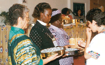 Una fotografía de damas presbiterianas administran y reparten 
el pan sin levadura y la copa.