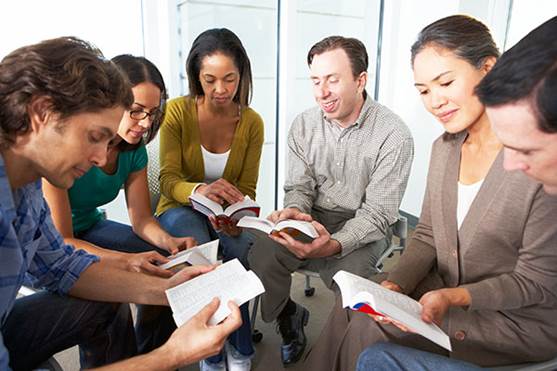 Foto de un grupo multiracial cuyos integrantes estudian la Biblia.