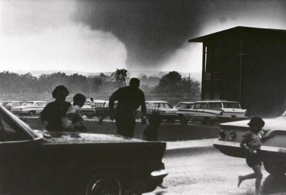 Fotografía icónica de una familia que huye de un gran tornado que se les acerca, ilustración para el artículo Beneficios de huracanes y otros fenómenos de la naturaleza.