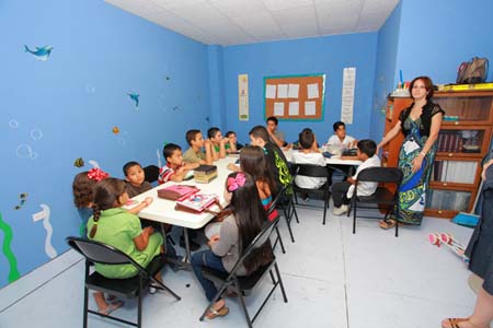 En esta fotografía, una maestra cristiana preparada, eficaz y activa enseña a un grupo de niños.