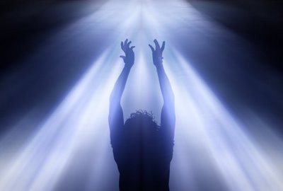 Una dama extiende sus manos en plegarias a Dios por iluminación espiritual, mientras fuertes rayos de luz blanca provenientes del Cielo brillan alrededor de ella, ilustración para el mensaje Espíritu presente y al mando, en editoriallapaz.