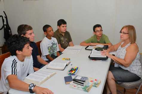 Una dama cristiana enseñan a una clase de cinco varónes jóvenes en la iglesia de Cristo, Alturas de Flamboyán, Bayamón, Puerto Rico.