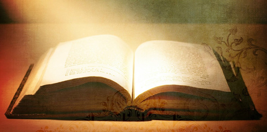 Rayos de luz iluminan Una Biblia abierta em señal de la inspiración divina que se atribuye a las Sagradas Escrituras.
