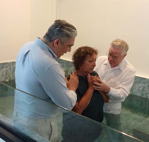 Dewayne Shappley and Armando Morales proceed to baptize Jenny for the forgiveness of sins.