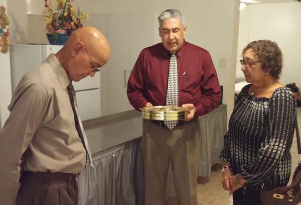 After her baptism, Jenny partakes of the Lord’s Supper, assisted by Armando Morales and José Álamo.
