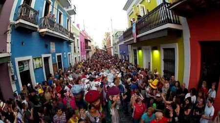 Fotografía de una calle del viejo San Juan, Puerto Rico, atestada de multitudes de fiesteros, ilustración para el tema Buscando de Dios y la Salvación en Puerto Rico.