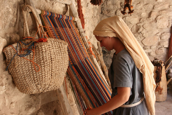 Una joven israelita teje telas de colores llamativos.
