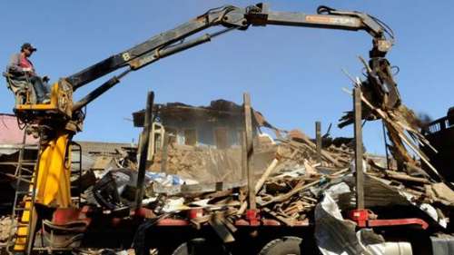 Una pintura artística sumamente realista de una ciudad costanera impactada por una enorme tsunami, viviendas, gentes, vehículos y barcos destruidos.
