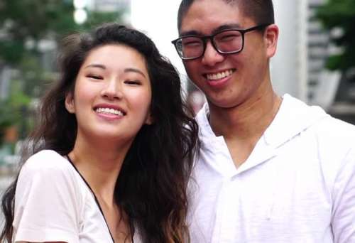 Fotografía de una pareja joven de raza oriental, la dama con pelo largo, el varón con espejuelos, ambos sonrientes, para el ensayo en torno a El color de vida humana.