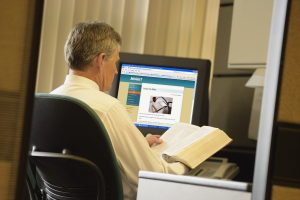 Fotografía de un varón con su Biblia abierta sentado frente a su computadora, ilustración para el tema Salvo siempre salvo escrutado.